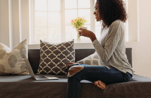 istock Woman enjoying a cup of coffee while working on laptop 1015263198