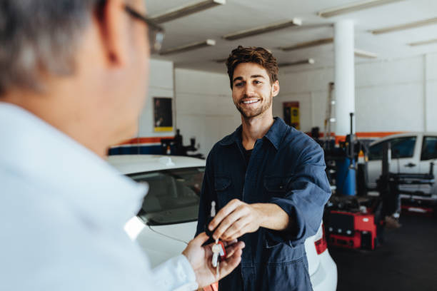 meccanico che dà le chiavi dell'auto al cliente dopo la manutenzione - auto repair shop garage car mechanic foto e immagini stock