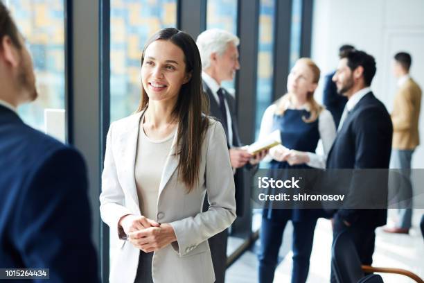 Pretty Business Lady Talking To Colleague Stock Photo - Download Image Now - Business, Meeting, Discussion