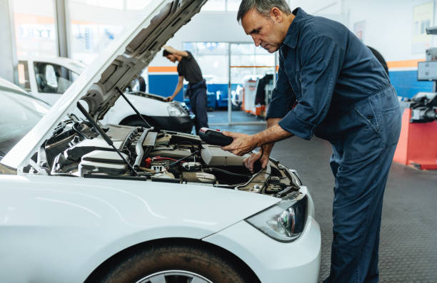 Mechanic reading the error codes with diagnostic device Car mechanic with diagnostic device for reading the error codes. Mechanic checking the car in service station. gas station photos stock pictures, royalty-free photos & images