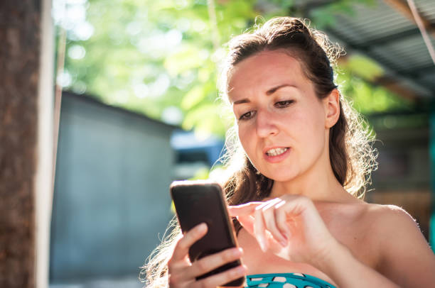 istock A girl in a bikini - Woman in bikini using phone 1015267182
