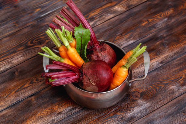 Fresh ripe vegetables bunch on rustic wooden background, metal pot