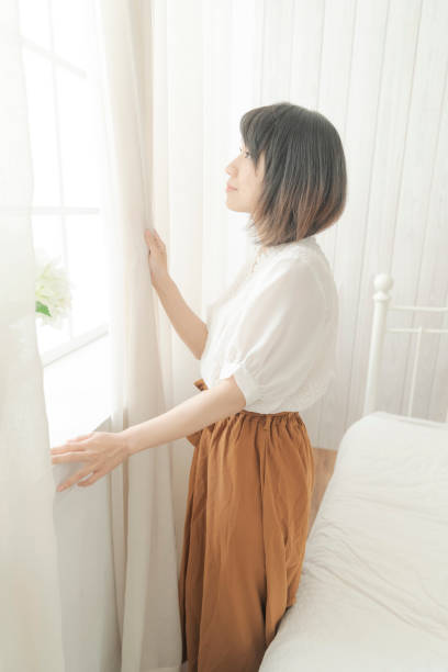 istock the 20s girl Get up and pull curtain. 1015280292