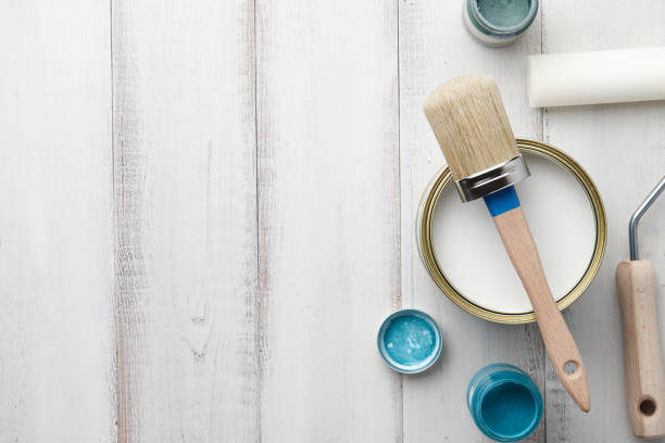 Paint, brush and other painting supplies on white wooden table Paint brush, sponge roller, paints, waxes and other painting or decorating supplies on white wooden planks, top view chalk art equipment stock pictures, royalty-free photos & images