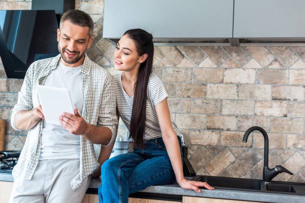 istock portrait of smiling couple using digital tablet together in kitchen, smart home concept 1015287312