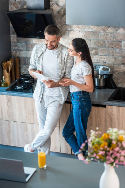 istock married couple using digital tablet together in kitchen, smart home concept 1015287316