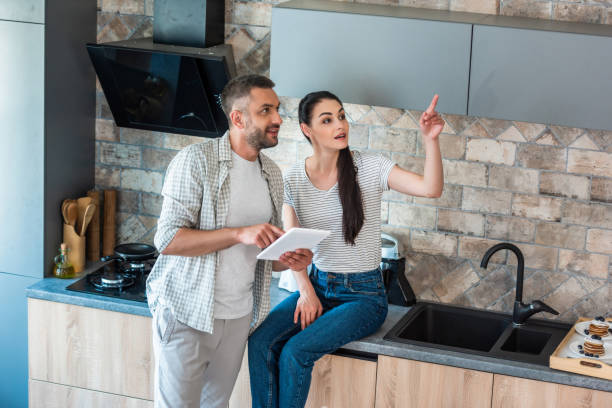 istock married couple with digital tablet looking away in kitchen, smart home concept 1015287484