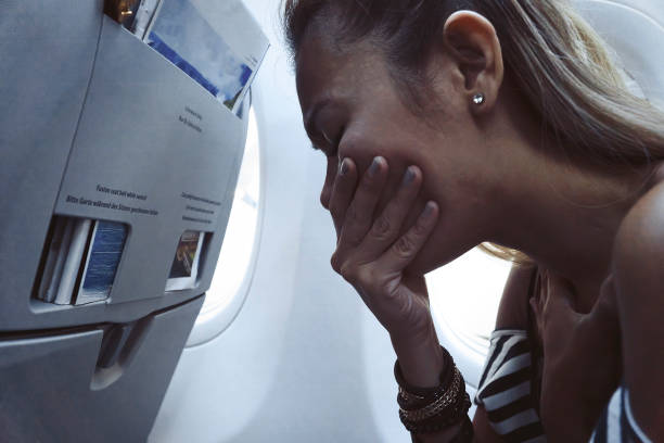 Woman feeling sick and puking in Airplane stock photo
