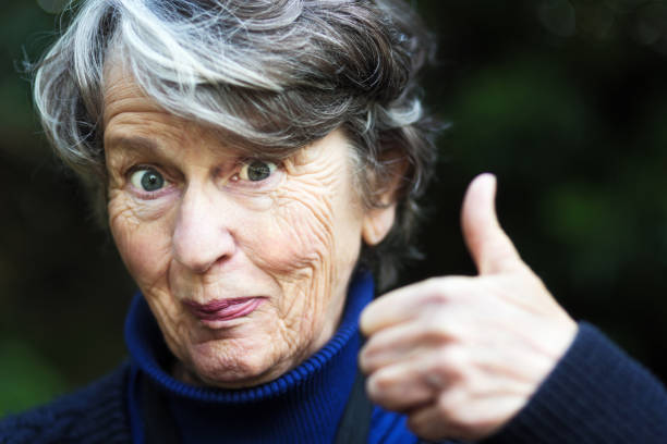 istock Perky senior woman gives a cheerful thumbs up 1015287708