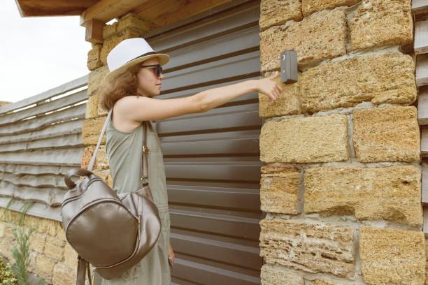 istock Outdoors girl calls the intercom, standing near the front door. 1015292496