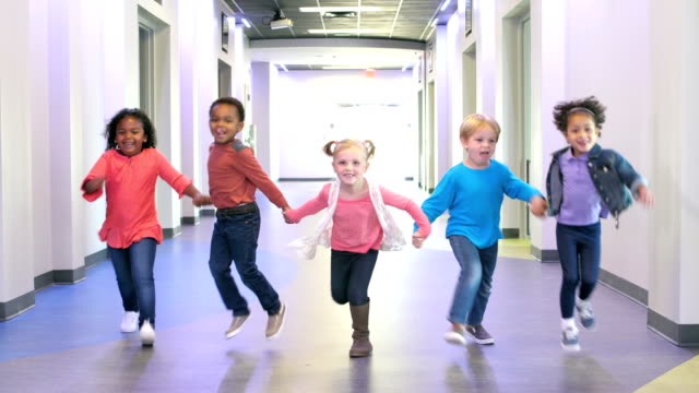 Five multi-ethnic preschool children holding hands