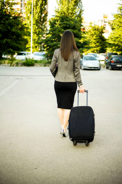 istock Businesswoman pulling a suitcase in a city 1015295398