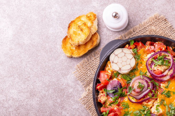 istock Shakshuka with toasts. Fried eggs with tomatoes, vegetables and herbs 1015295596