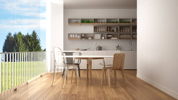 istock Minimalist white and wooden kitchen with dining table and big panoramic window. Meadow with green grass, trees and blue sky in the background. Eco house interior design 1015304494