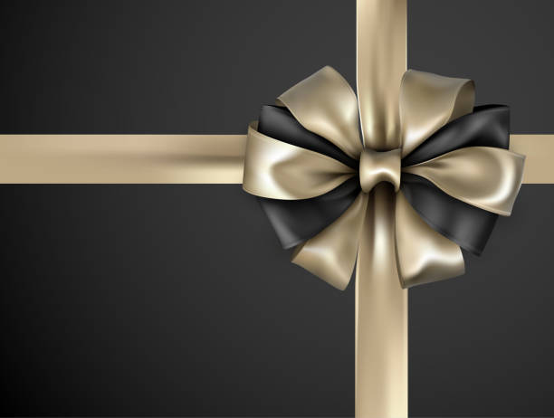 istock Gold bicolour ribbon with bow isolated on black. 1015305728