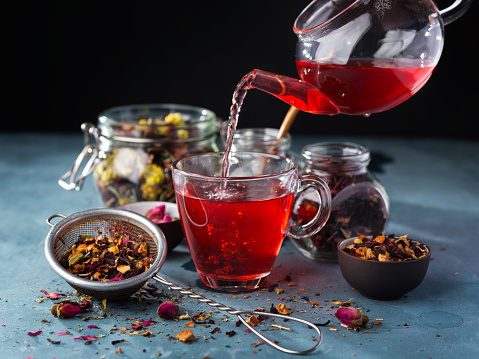 Proceso elaboración de la cerveza té, ceremonia del té, taza de fruta recién hecho y té de hierbas, humor oscuro. Agua caliente se vierte de la Hervidora de agua en un recipiente con hojas de té. photo