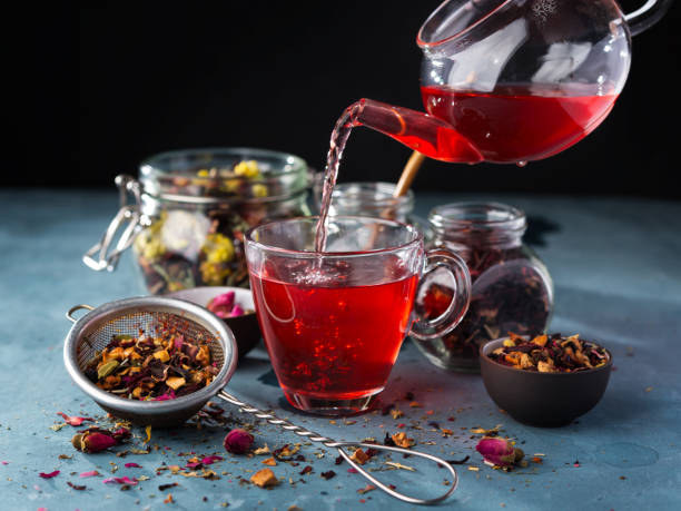 proceso elaboración de la cerveza té, ceremonia del té, taza de fruta recién hecho y té de hierbas, humor oscuro. agua caliente se vierte de la hervidora de agua en un recipiente con hojas de té. - herbal tea fotografías e imágenes de stock