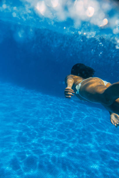 istock Girl underwater diving in a swimming pool 1015309292