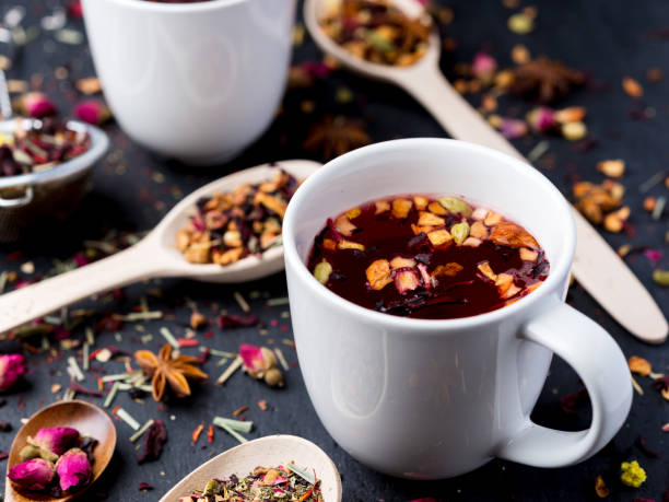 istock Fruit and herbal tea in two white cup on dark concrete background. 1015309576