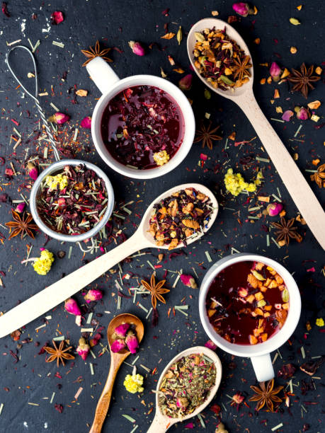 Fruit and herbal tea in two white cup on dark concrete background.