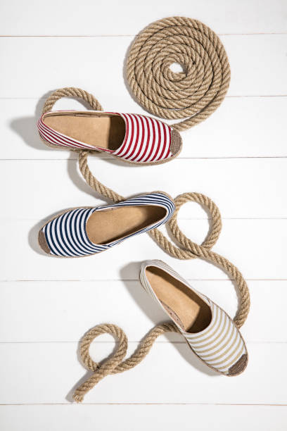 Striped Espadrilles isolated on wooden background Striped Espadrilles isolated on wooden background (with clipping path) flat shoe stock pictures, royalty-free photos & images