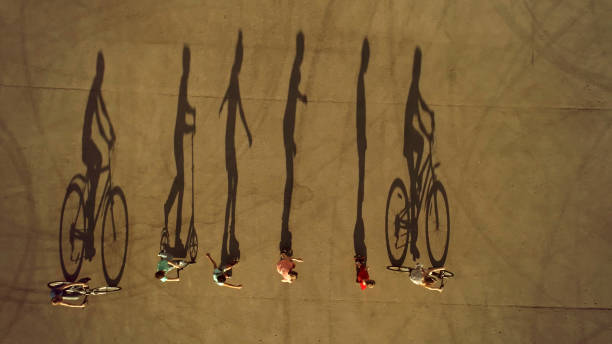 istock Kids on Wheels Cast Long Shadows. Cycling, Roller Skating and Scootering 1015315362