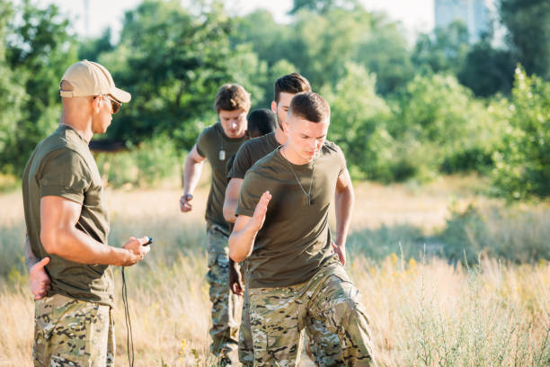 istock tactical instructor with stop watch examining multiracial soldiers during obstacle run on range 1015321308