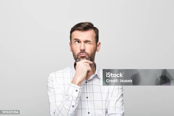 Portrait Of Pensive Businessman Grey Background Stock Photo - Download Image Now - Asking, Businessman, Manager