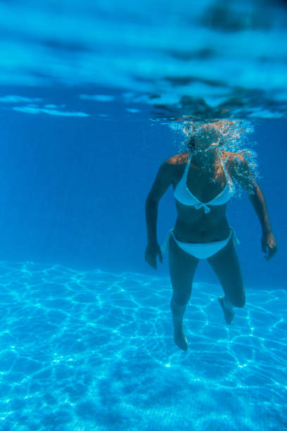 istock Girl underwater in a swimming pool 1015323682