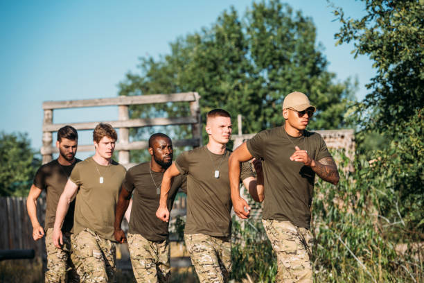 istock multiethnic soldiers in military uniform running on range 1015323996