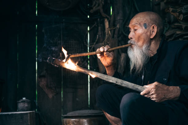 istock old chinese senior man lighting smoking pipe 1015327118