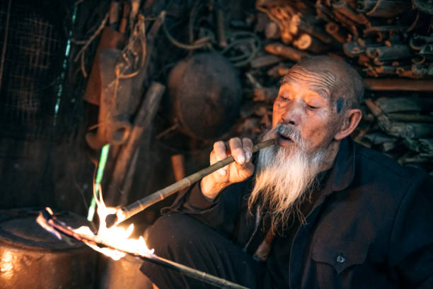istock old chinese senior man lighting smoking pipe 1015327344