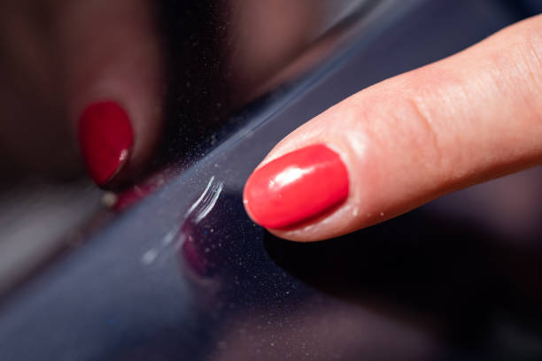 Scratches in a car paint A woman shows scratches in a car paint. scuff marks photos stock pictures, royalty-free photos & images