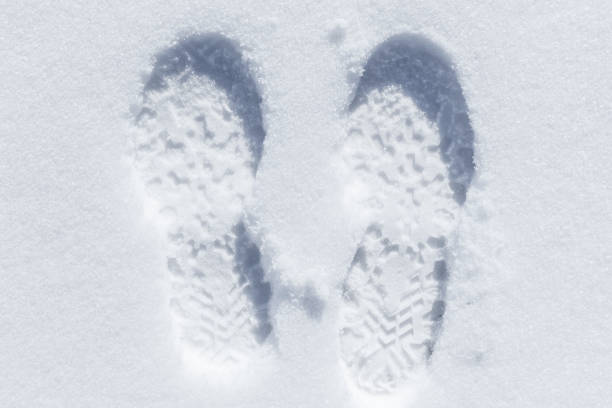 istock Feet imprint in white snow, close-up 1015327620
