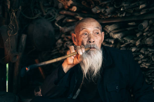 istock pensive old chinese senior man smoking pipe 1015328012