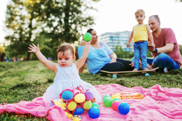 Modern real parents with body positive attitude, tattoos, piercings and positive lifestyle, spending afternoon with their kids in the park.