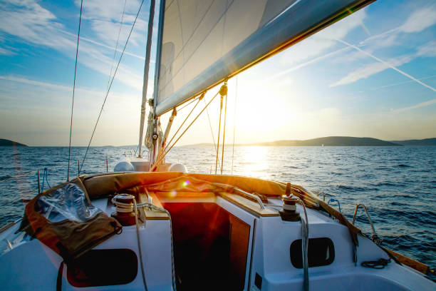 veleiro cruzando ao entardecer - moody sky water sport passenger craft scenics - fotografias e filmes do acervo