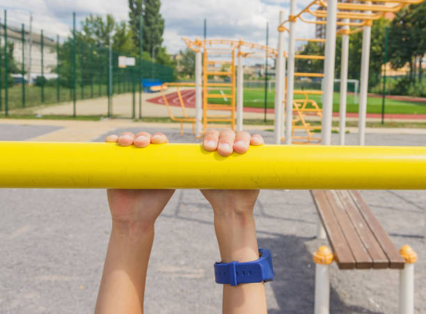 5 years boy's hands on a horizontal bar, sports ground for children. Playground. 5 years boy's hands on a horizontal bar, sports ground for children. Playground. gripping bars stock pictures, royalty-free photos & images