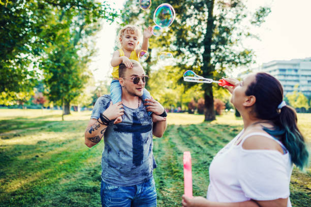 istock Mom and dad playing with son and using bubble wand 1015335712