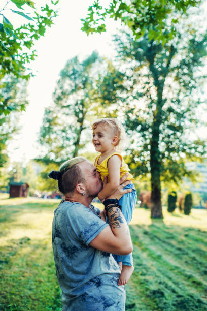 istock Modern  father holding his son up and kissing him 1015336810