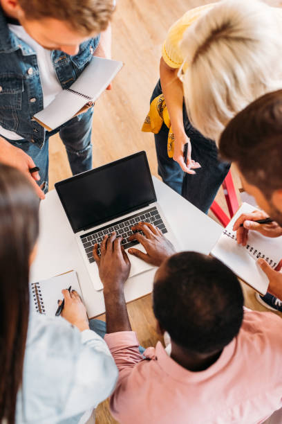 istock high angle view of young students using laptop together at college 1015350420