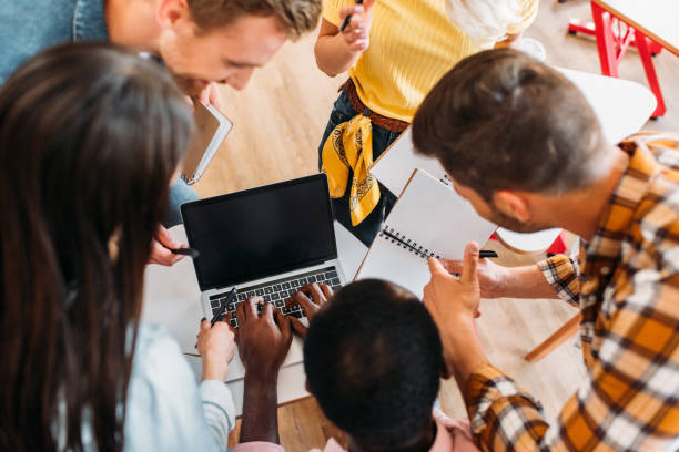 istock high angle view of multiethnic young students using laptop together at college 1015350494