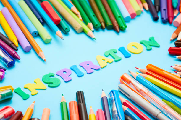 istock Many mixed pens, pencils, crayons surround word INSPIRATION on blue 1015354598