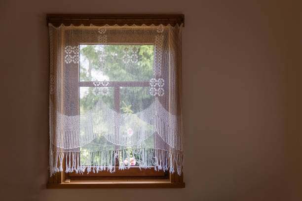 istock Folk crochet curtains on the wooden window 1015355802