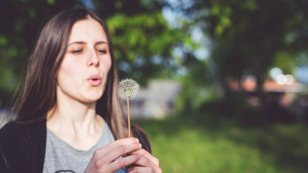 istock Young woman blows dandelion 1015357910