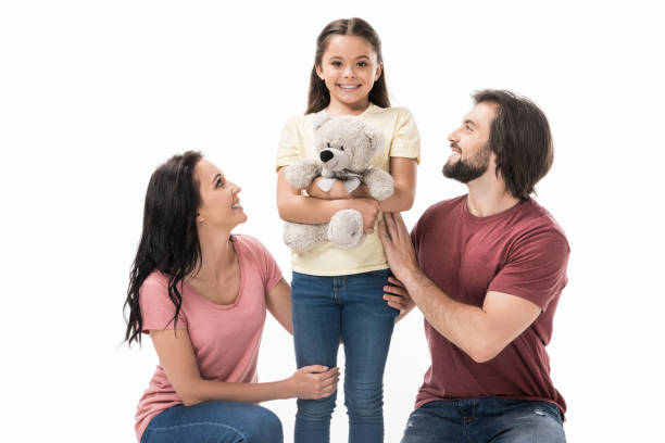 istock smiling parents and daughter with teddy bear isolated on white 1015371436