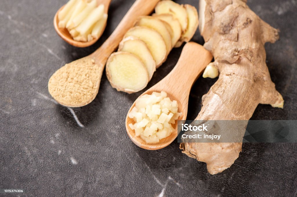 Ginger root, ginger slice and ginger powder on stone background table, space for text. Ginger - Spice Stock Photo