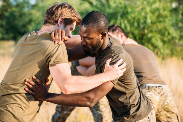 istock multiracial soldiers in military uniform practicing hand to hand fighting on range 1015375280