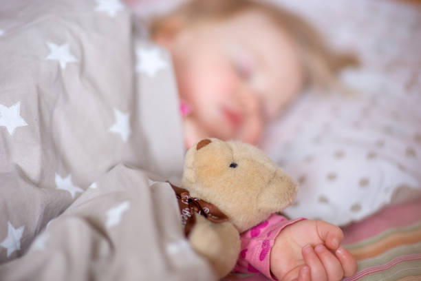 istock Sleeping baby with a toy bear. 1015381428