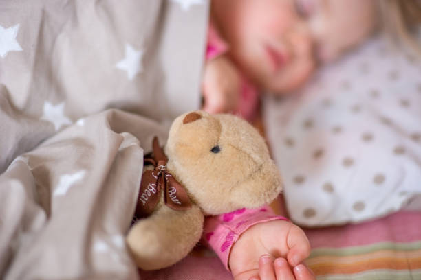 istock Sleeping baby with a toy bear. 1015381458